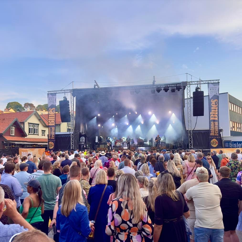 Utescene med lysrigg og publikum i kveldslys.